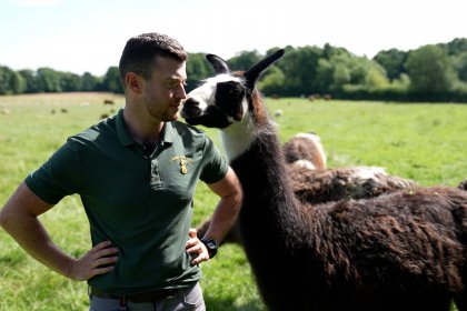 Photo of farmer Alex with a llama at Cannon Hall Farm