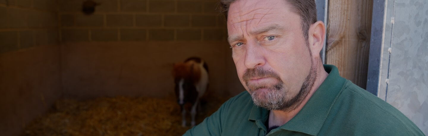 Photo of Farmer Daryl with a Shetland pony in an enclosure