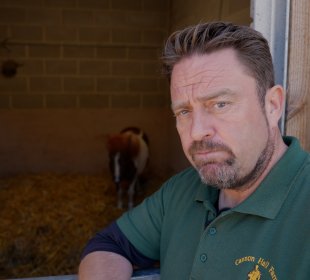 Photo of Farmer Daryl with a Shetland pony in an enclosure