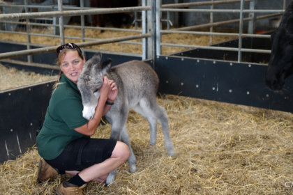 Photo of Ruth Burgess with baby donkey Shirley