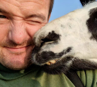 Photo of Farmer Alex with a llama