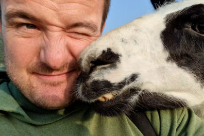 Photo of Farmer Alex with a llama